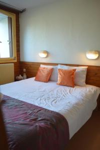 ein großes weißes Bett mit zwei Kissen darauf in der Unterkunft Résidence du Val de Villé in Albé