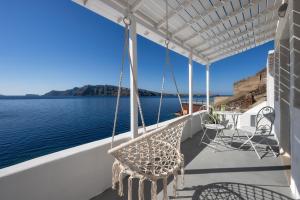 a porch with chairs and a view of the water at Lava Stone in Oia