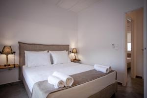 a bedroom with a white bed with towels on it at Athena΄s Residency / Mykonos Town in Mikonos