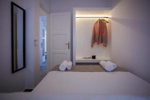 een witte kamer met een bed en een kast bij Athena΄s Residency / Mykonos Town in Mykonos-stad