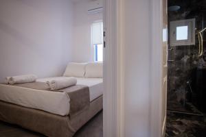 a white couch in a room with a window at Athena΄s Residency / Mykonos Town in Mikonos
