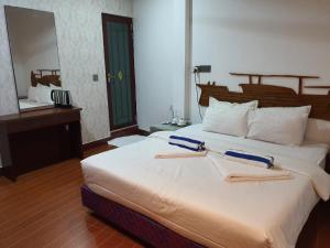 1 dormitorio con 1 cama grande y 2 toallas. en Guraidhoo Palm Inn, en Guraidhoo