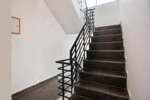 una escalera con barandillas negras en una casa en Super OYO Dream Town, en Nueva Delhi