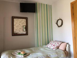 um quarto com uma cama, um espelho e uma fotografia em Casa Catharina em La Seu d'Urgell