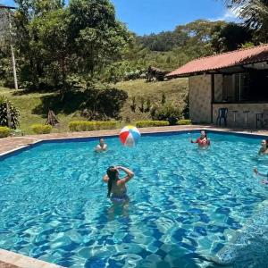 un gruppo di persone che giocano con un pallone da spiaggia in piscina di FINCA HOTEL TIERRA NUEVA CAMPESTRE a La Vega