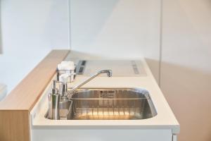 eine Küchenspüle mit einem Wasserhahn auf der Theke in der Unterkunft 09 Resort Club -Green- in Azagawa + 78 Fotos