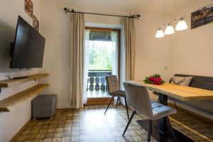 een woonkamer met een tafel en stoelen en een televisie bij Ferienhof Alfred Albrecht in Oberstdorf