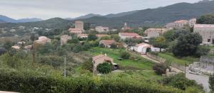 een klein stadje met bergen op de achtergrond bij Maison en pierre de taille in Petreto-Bicchisano