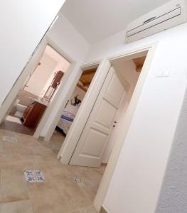 un corridoio con pareti bianche e una porta di Apartment Conchiglie 2 a Cala Gonone