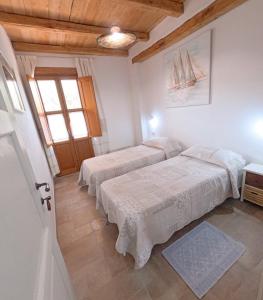 um quarto com 2 camas e uma janela em Apartment Conchiglie 2 em Cala Gonone