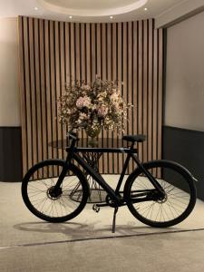 Una bicicleta negra con un jarrón de flores sobre una mesa en Aparthotel Los Girasoles, en Zaragoza