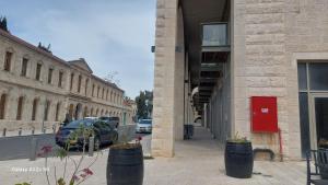 een straat met auto's aan de zijkant van een gebouw bij malka house in El Muṣrāra