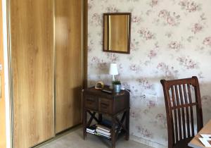 Zimmer mit einem Tisch und einem Spiegel an der Wand in der Unterkunft Casa Catharina in La Seu d'Urgell
