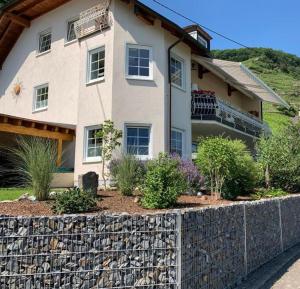 a house with a stone retaining wall in front of it at Villa Ferres in Piesport