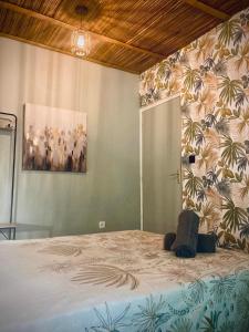 Schlafzimmer mit einem Bett mit Wandgemälde in der Unterkunft Mika & Clo in Saint-Joseph