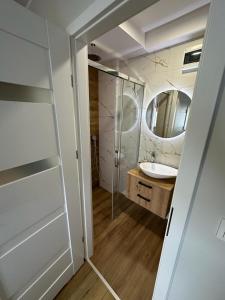 een badkamer met een wastafel en een spiegel bij Pokoje przy Kawiarence in Rewa
