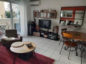 貝格勒的住宿－Douceur et cocooning，客厅配有电视和桌椅
