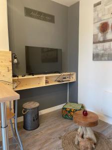 een woonkamer met een tv en een tafel en een kruk bij Logement entier: Appartement avec Terrasse Quartier de la Gare in Amboise