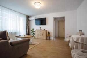 a living room with a couch and a tv at Perfect Apartment Central in Braşov