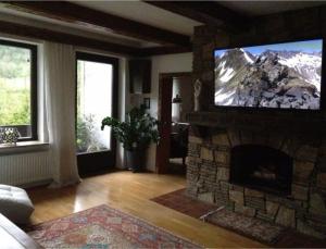 uma sala de estar com uma televisão em cima de uma lareira de pedra em Landhaus Tamberg im Schi-Weltcup-Ort Hinterstoder em Hinterstoder