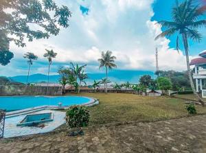 - une piscine dans une cour avec des palmiers dans l'établissement Villa Griya Puspita, à Kopo 2