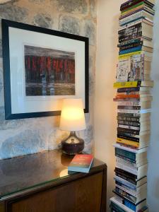 a lamp on a table with a stack of books at The Olive Tree in Begovići