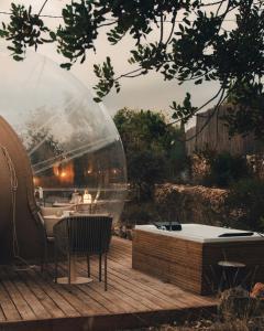 een glazen bubbel op een houten terras met een hot tub bij Noches de Calig in San Jorge