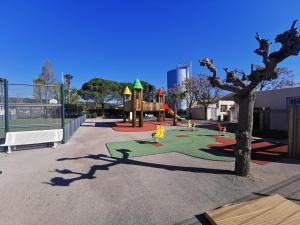 a park with a playground with a tree at Mobil-Home en camping**** in Vic-la-Gardiole