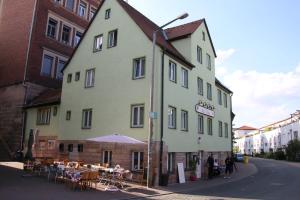 a large white building with tables and chairs on a street at Haus99 Heiligenstrasse in Fürth