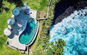 an overhead view of a swimming pool next to the ocean at Bali Cliff Glamping in Seraya
