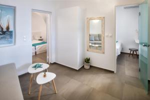 a room with a mirror and two chairs and a bed at Lava Stone in Oia