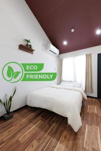 a bedroom with two beds and an ego friendly sign on the wall at 西九条 CHILL - Nishikujo CHILL in Osaka