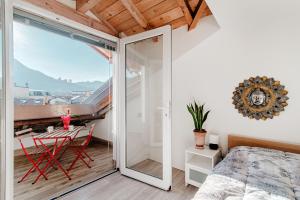 a bedroom with a balcony with a bed and a table at Casa di Diego in Como
