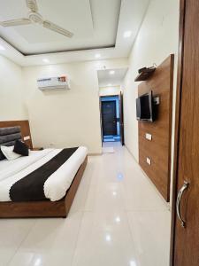ein Schlafzimmer mit einem Bett und einem TV an der Wand in der Unterkunft The Woodlark !! Managed by Sidham Hospitality !! in Chandīgarh