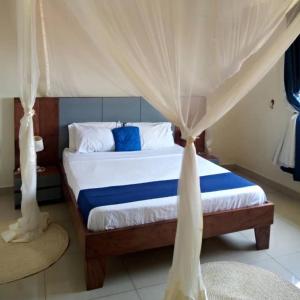 a bedroom with a bed with a canopy at The Abode Apartments Lake view & Breakfast Suite Near Beach in Entebbe
