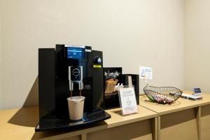 Kyohotel Kishotei Goshominami في كيوتو: آلة القهوة موجودة على منضدة بها