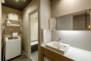 a bathroom with a sink and a mirror at Kyohotel Kishotei Goshominami in Kyoto