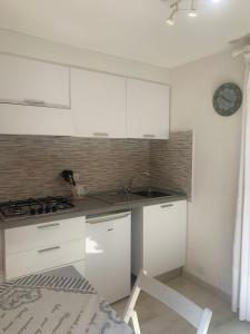 a kitchen with white cabinets and a stove at Monolocale “La Panoramica” in Rio Marina