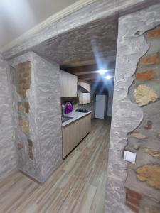 eine Küche mit einer Steinmauer in einem Zimmer in der Unterkunft Guest House Lakada in Kutaissi
