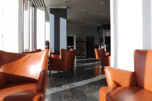 a row of brown chairs in a waiting room at Milling Hotel Søpark in Maribo