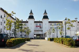 un gran edificio blanco con dos torres en la parte superior en Milling Hotel Søpark, en Maribo