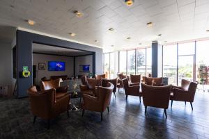 a waiting room with chairs and a table and windows at Milling Hotel Søpark in Maribo