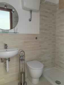 ein Badezimmer mit einem WC, einem Waschbecken und einem Spiegel in der Unterkunft Monolocale “La Panoramica” in Rio Marina
