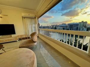 a room with a balcony with a view of a city at Nile view Zamalek Abuelfeda's Three bedrooms in Cairo