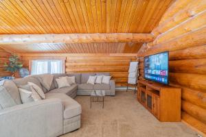 a living room with a couch and a flat screen tv at Tucked Away Timber Upper Suite in Fairbanks