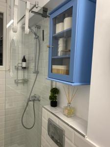 y baño con armario azul y ducha. en Hey Central Apartment, en Timisoara