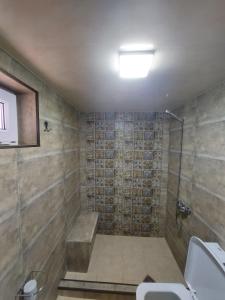 ein Bad mit einer Dusche und einem Waschbecken in der Unterkunft Guest House Lakada in Kutaissi