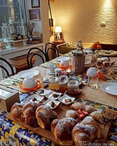 einen Tisch mit Croissants und anderem Gebäck darauf in der Unterkunft La casetta di Jasmine in Salerno