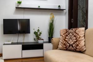 a living room with a tv on a white entertainment center at Central Apartment ressidence city in Bucharest