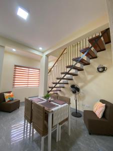 a living room with a table and a staircase at Greenview Terraces in Kay Riapay